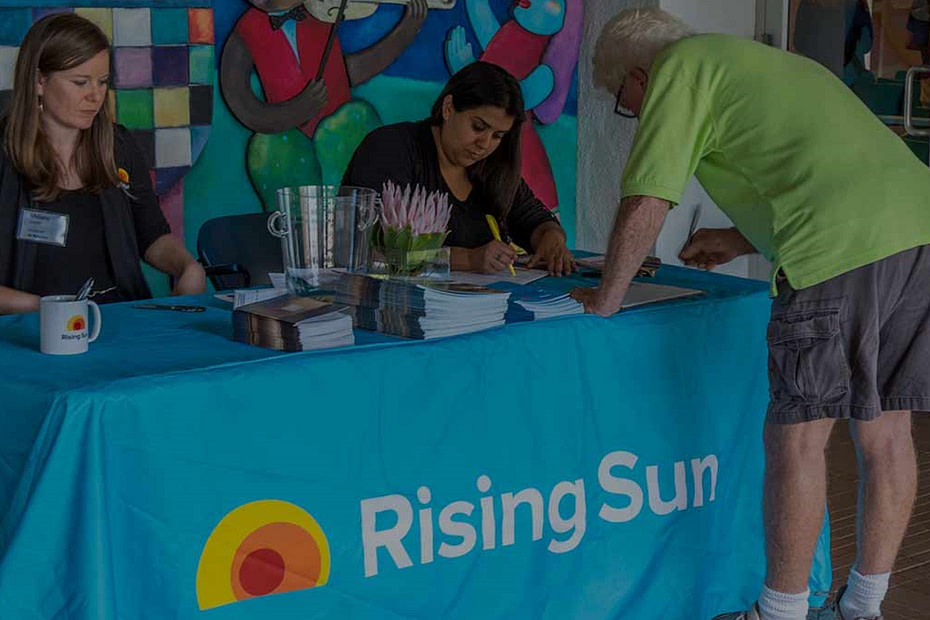 people signing up for rising sun information siting at a table
