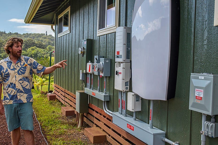 rising sun solar employee showcasing tesla powerwall installed on customer home