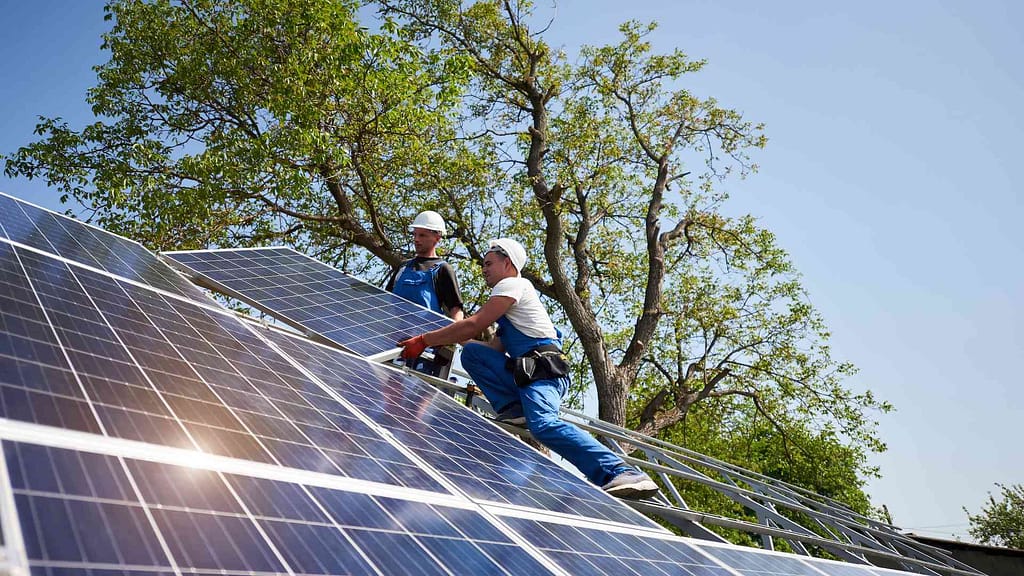 two men installing solar panels by one of the largest hawaii solar companies Rising Sun
