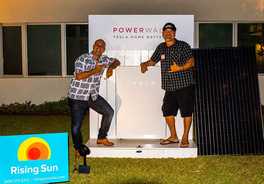 two men standing over powerwall tesla home battery platform