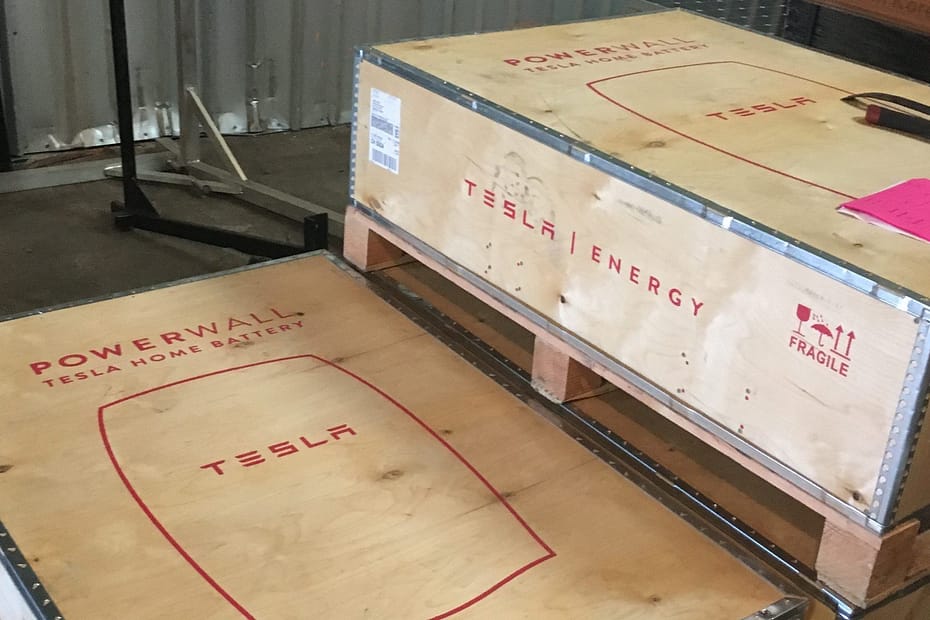 tesla powerwalls in their shipping boxes ariving at rising sun solars warehouse